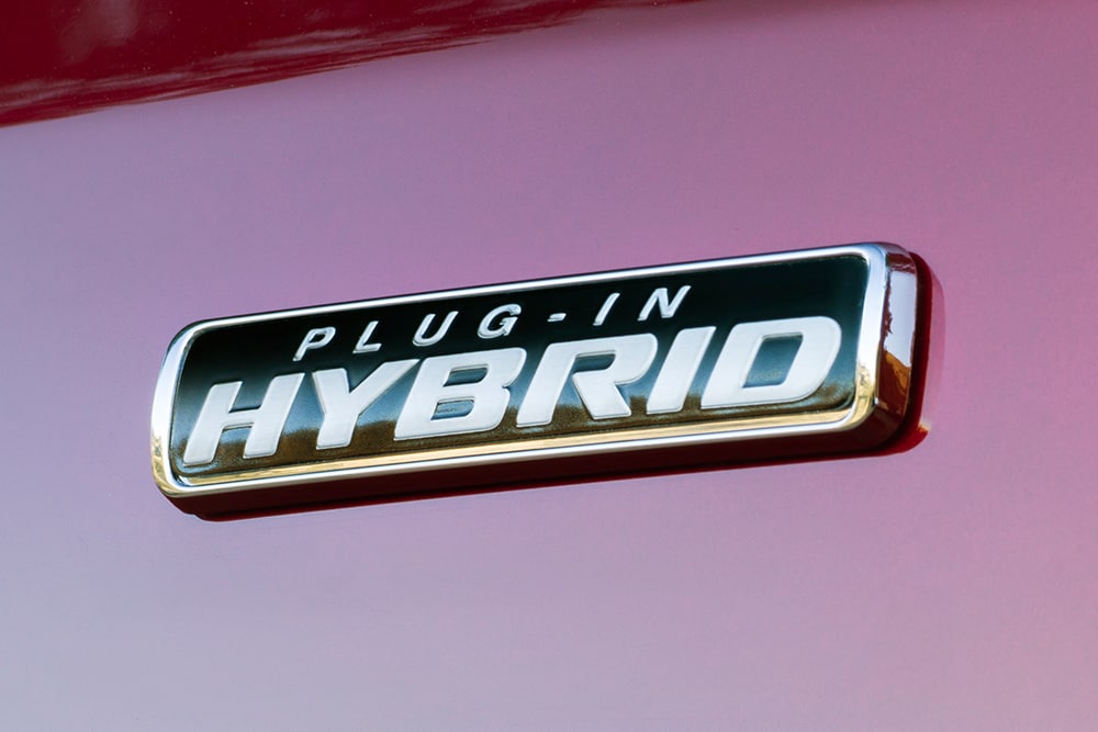 Emblème « Plug-in Hybrid » sur une Ford Transit Custom rouge. 