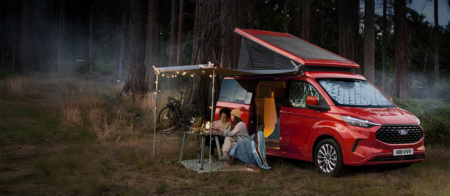 Ford Transit Custom Nugget Camper rouge dans la forêt