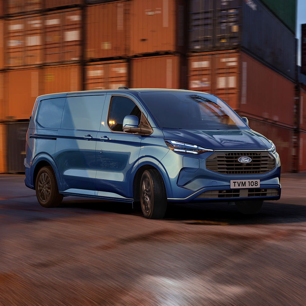 Blue Ford Transit Custom Plug-in Hybrid van drives through a dock yard.