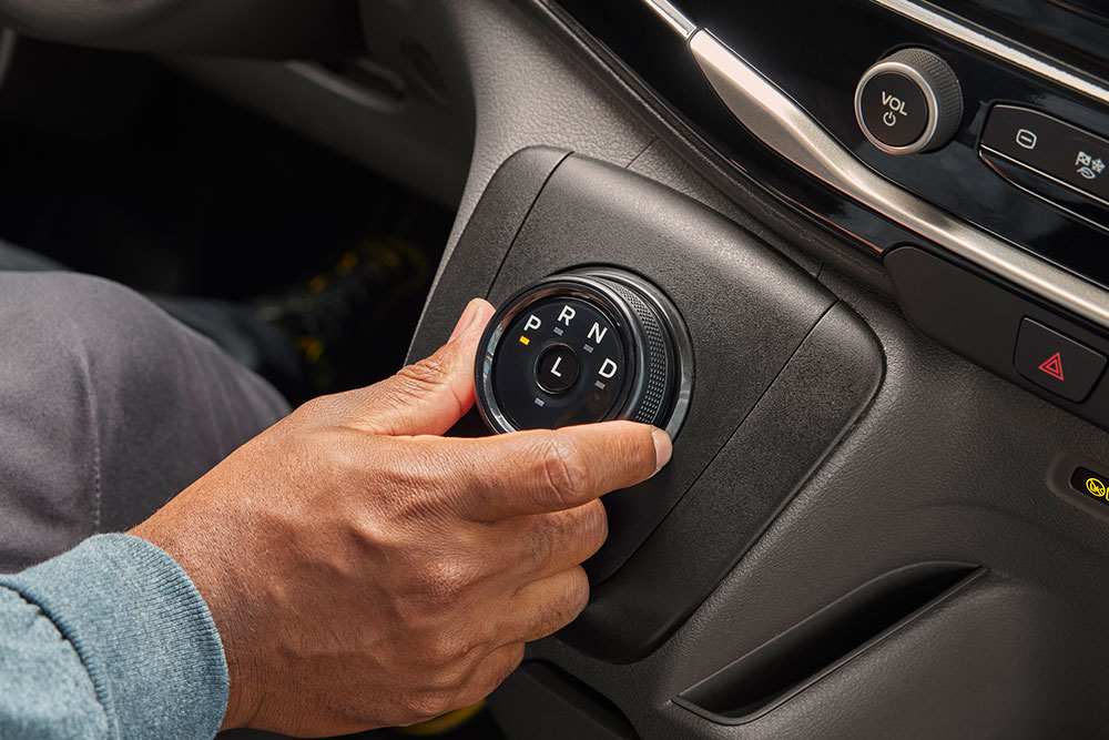 Gros plan d'une main tournant le sélecteur de vitesses dans une fourgon électrique Ford E-Transit.