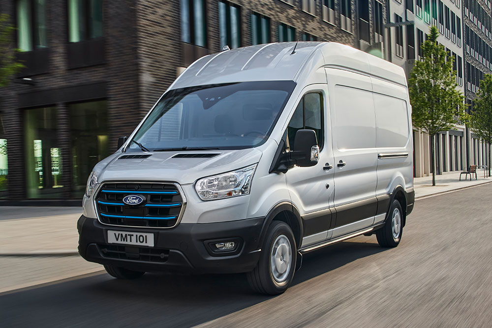 Fourgon Ford E-Transit roulant dans une rue.