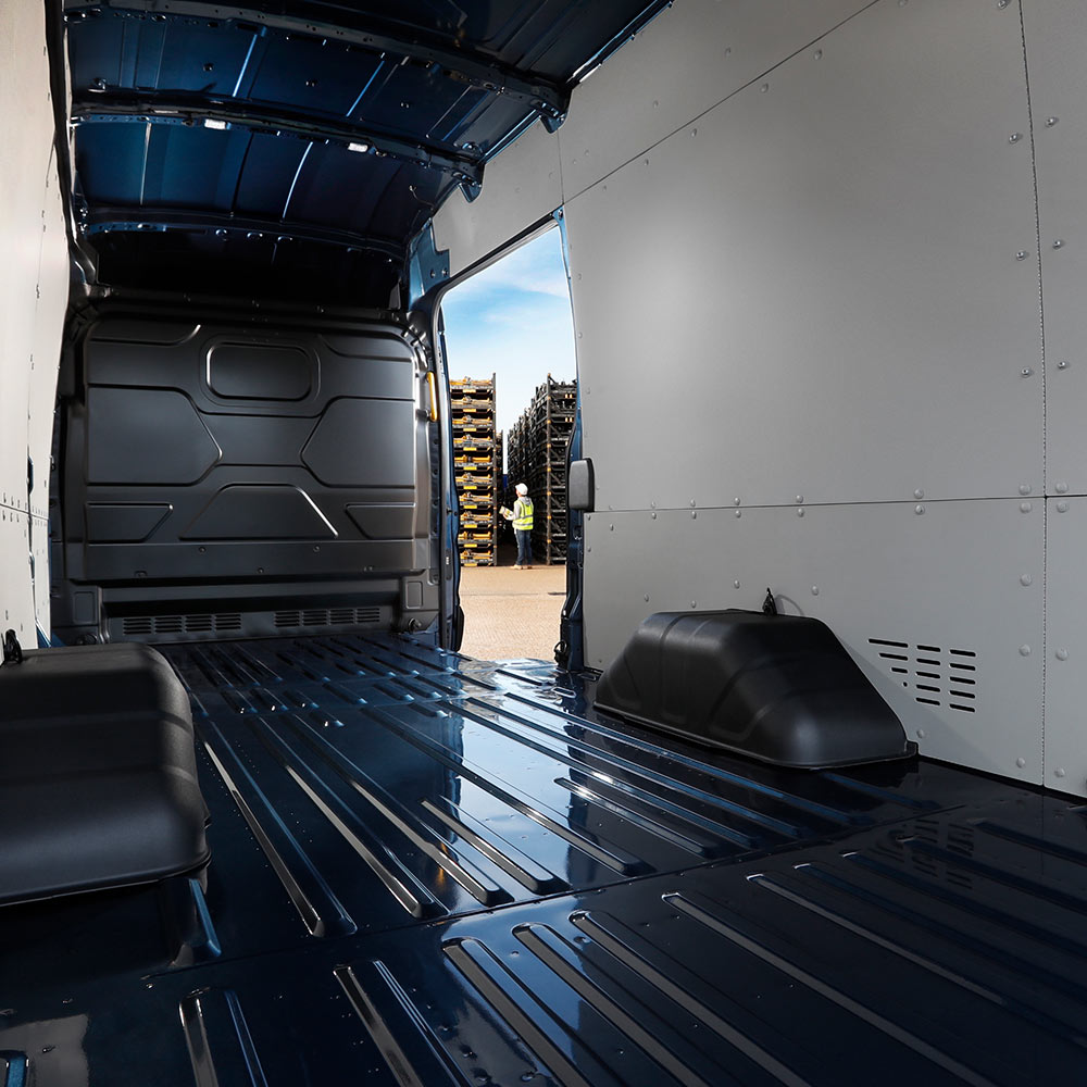 Intérieur d'un fourgon Ford électrique E-Transit avec un espace de chargement vide.