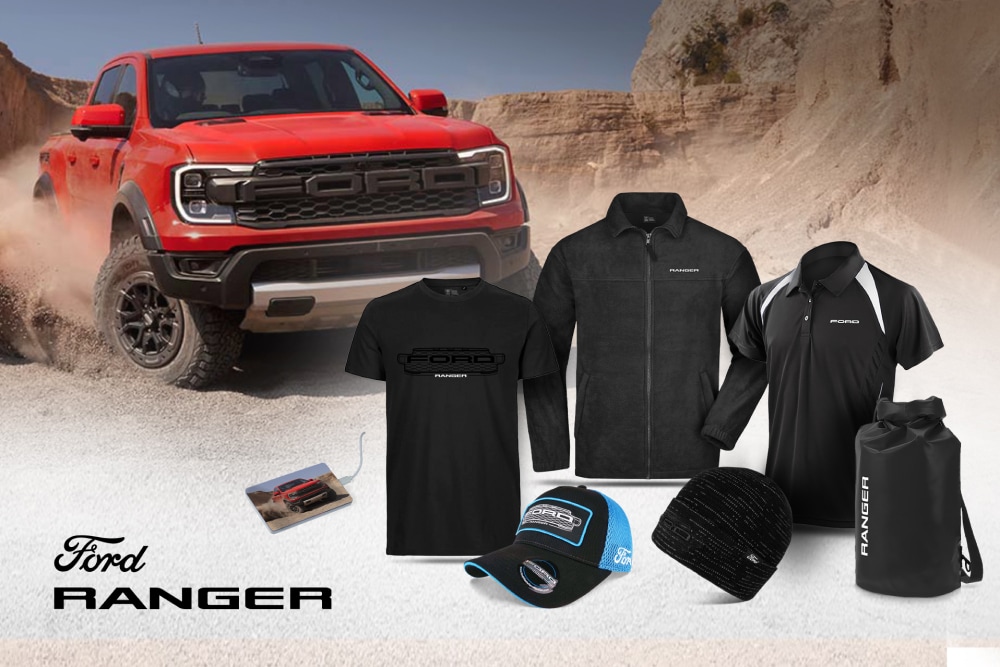 Collection Ford Ranger avec t-shirt, veste, polo, casquette, bonnet et sac étanche noirs, et un Ranger rouge en arrière-plan. 