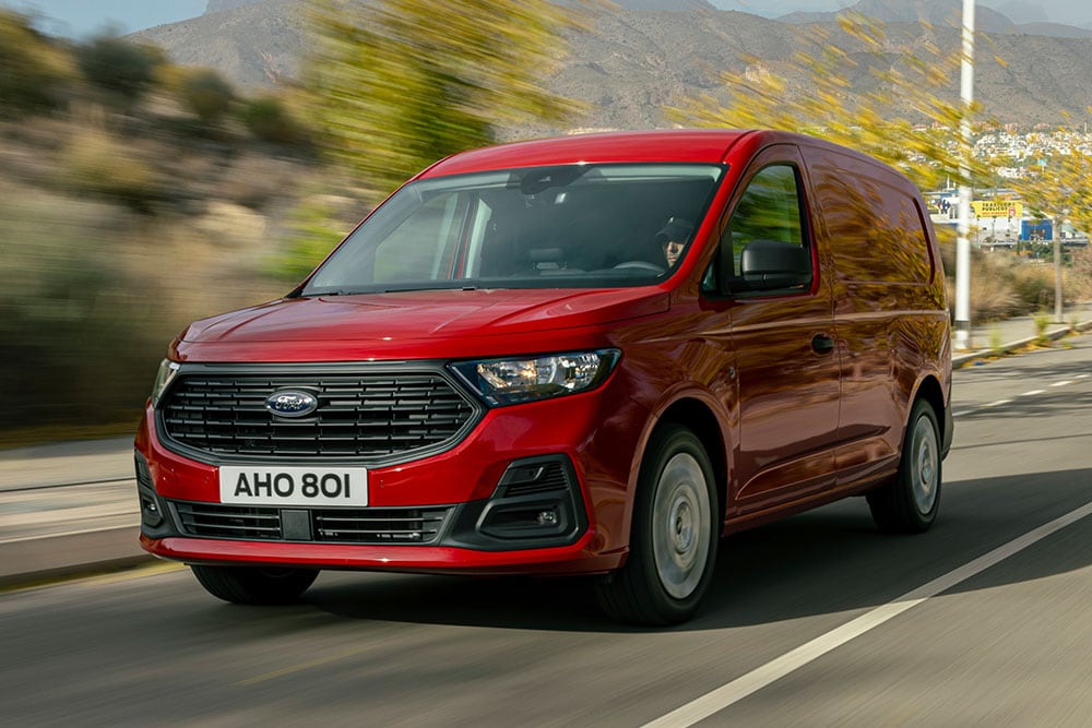Ford Transit Connect circulant sur une route et montrant la calandre et les phares automatiques.