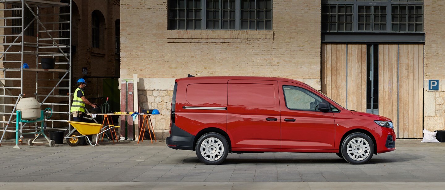 Le Ford Transit Connect® en Maple Red avec porte de chargement latérale sur un chantier.