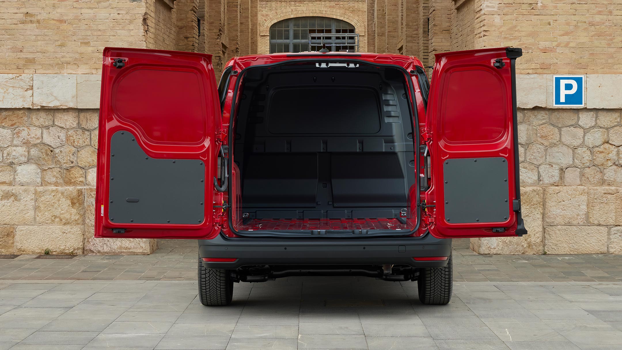 La cloison de séparation du Ford Transit Connect en Maple Red est visible à travers les portes ouvertes.