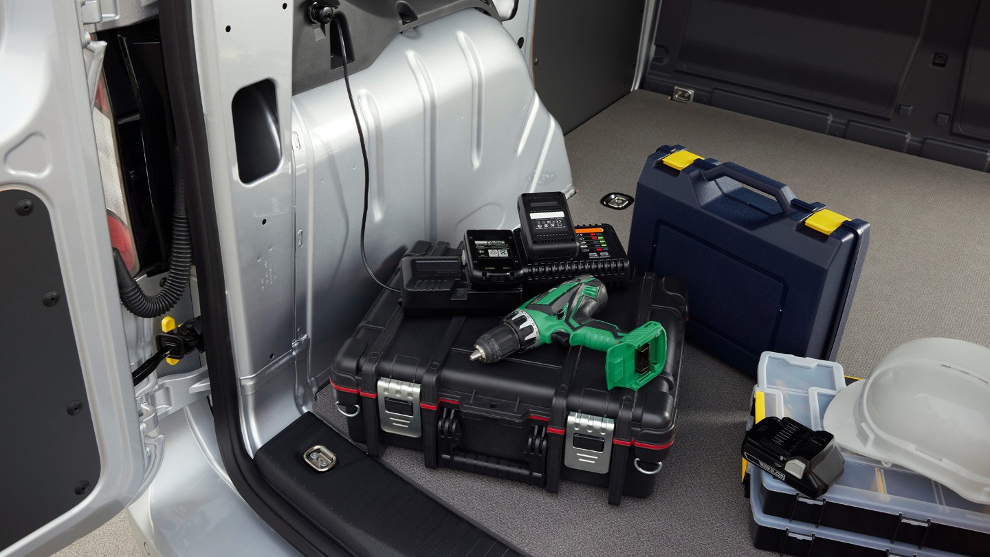 Une perceuse est branchée sur une prise 12 V dans l’espace de chargement du Ford Transit Connect.