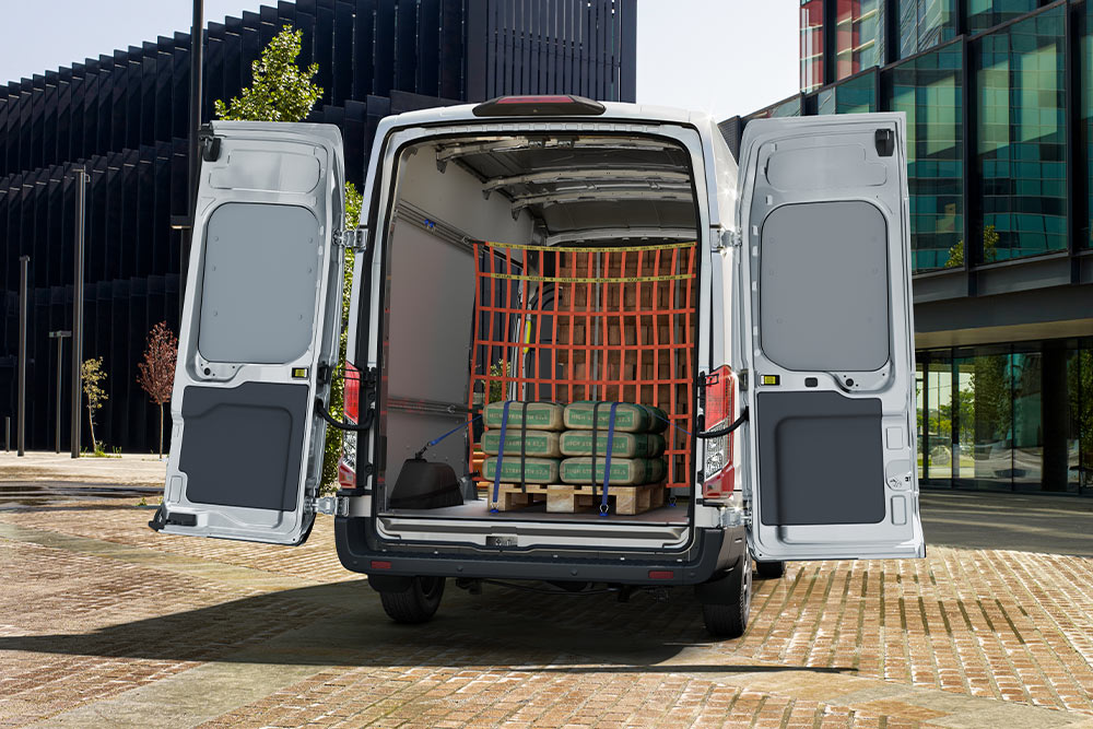 Un Ford Transit Fourgon avec ses portes arrière ouvertes et un chargement à l'intérieur.