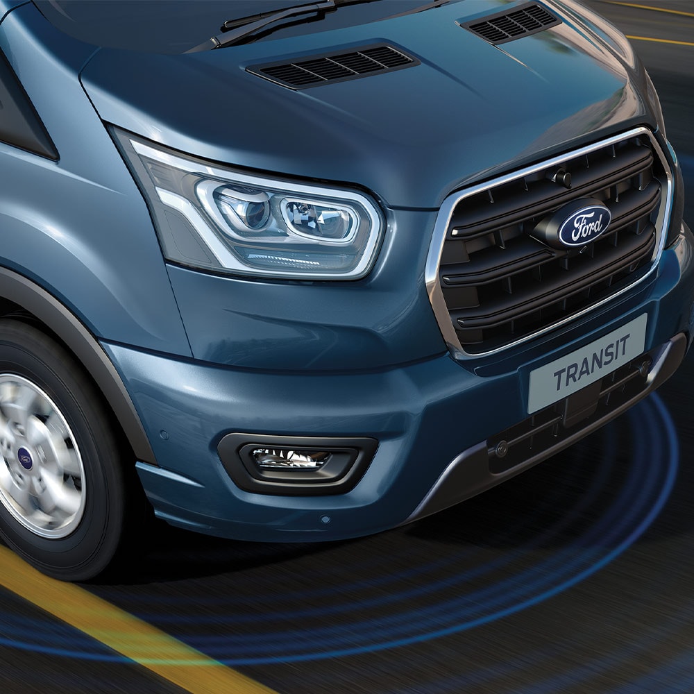 Ford Transit Fourgon bleu avec des lignes bleues sur la route illustrant l'usage des systèmes avancés d'aide à la conduite.
