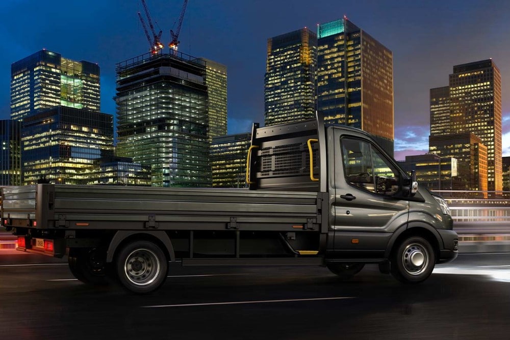 Le châssis cabine Ford Transit circule dans une ville, la nuit. 