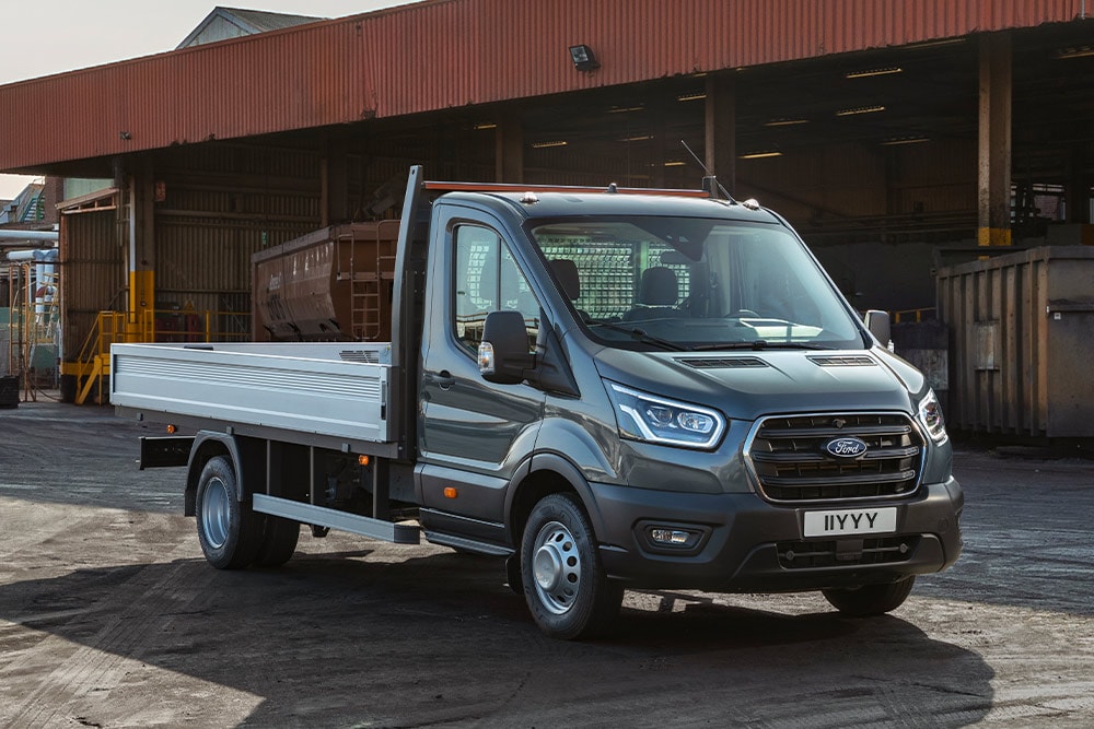 Châssis cabine Ford Transit stationné dans une zone industrielle.