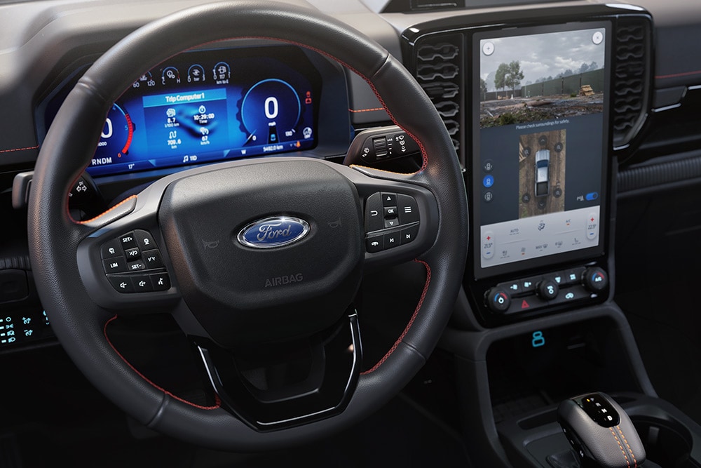 Vue intérieure du Ford Ranger Wildtrak montrant le volant et l’écran tactile SYNC™ 4 de 12 pouces de la console centrale.
