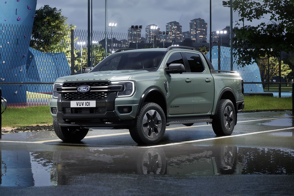 Ford Ranger PHEV gris garé et paysage urbain au crépuscule en arrière-plan.