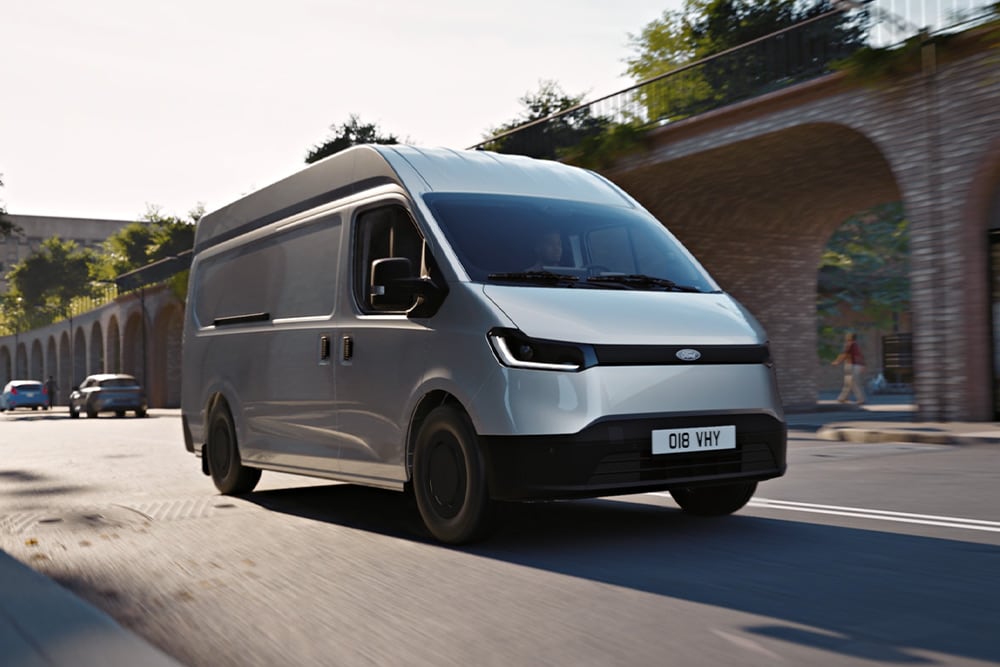 Un fourgon Ford Transit City® L1 H1 blanc circulant dans une rue de ville.