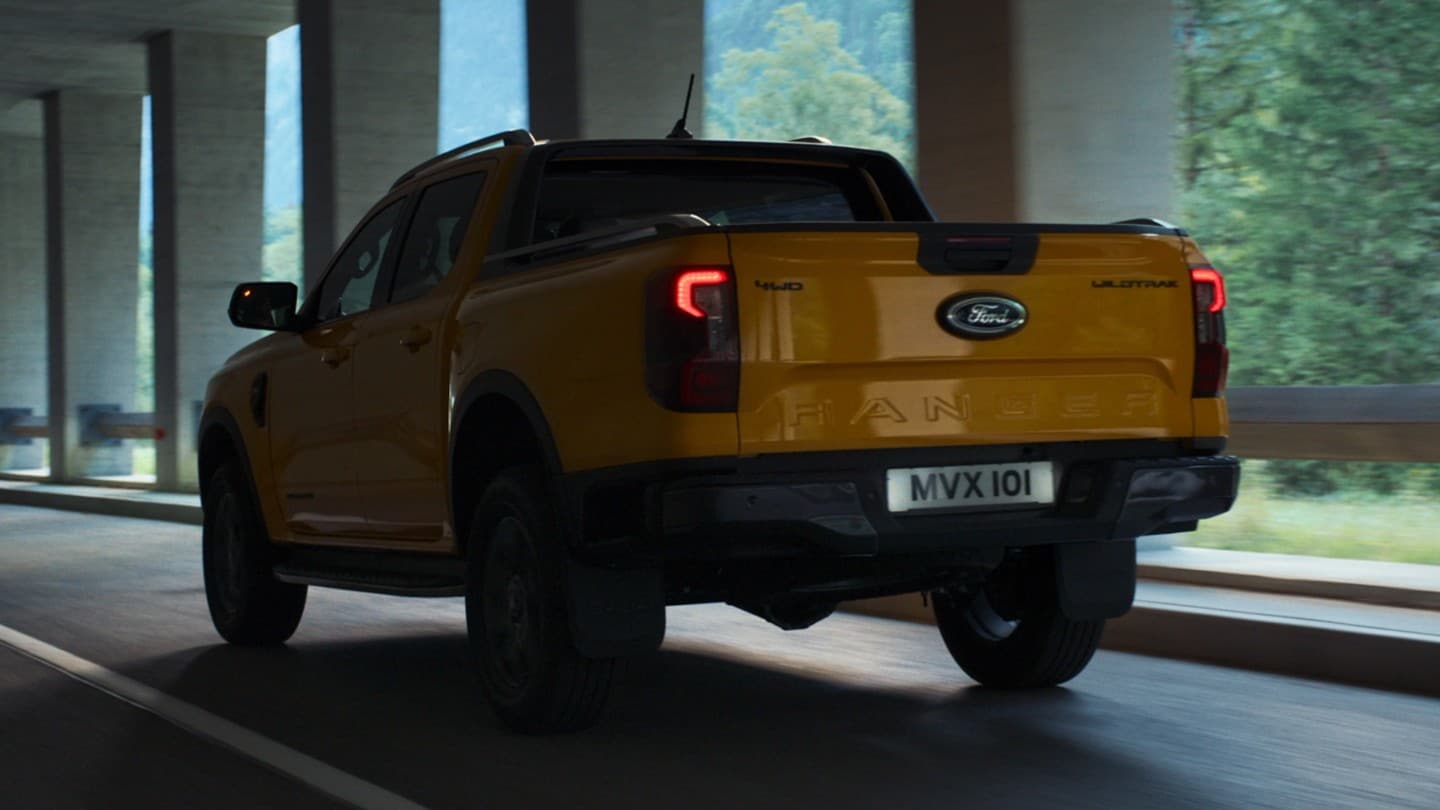 Vue arrière de 3/4 du tout nouveau Ford Ranger passant sous un pont