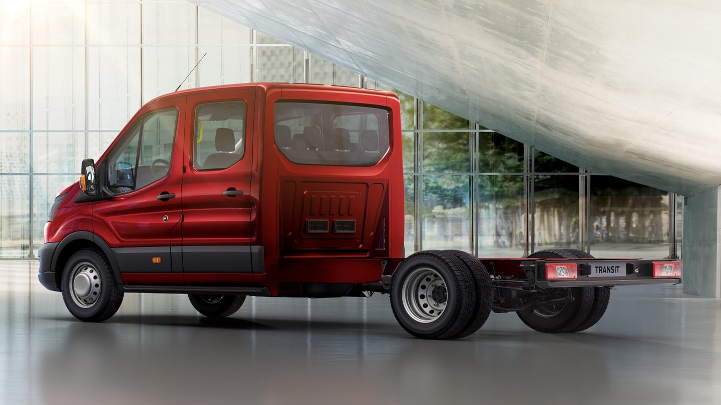 Ford Transit Châssis-Cabine rouge, vue latérale aux trois quarts dans une halle d’exposition