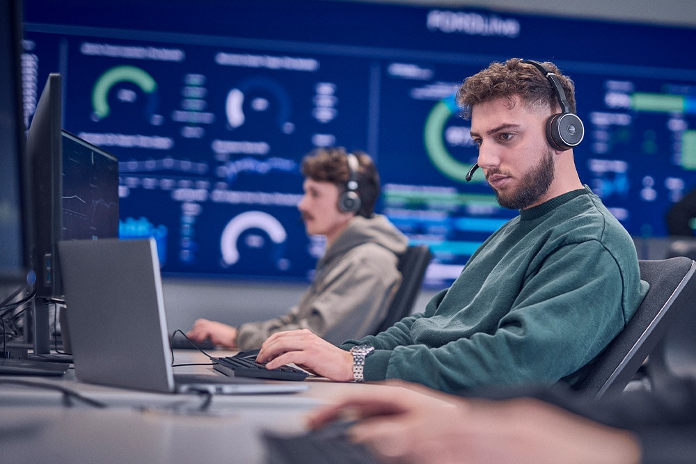 Un employé de Ford portant un casque et travaillant sur son ordinateur portable.