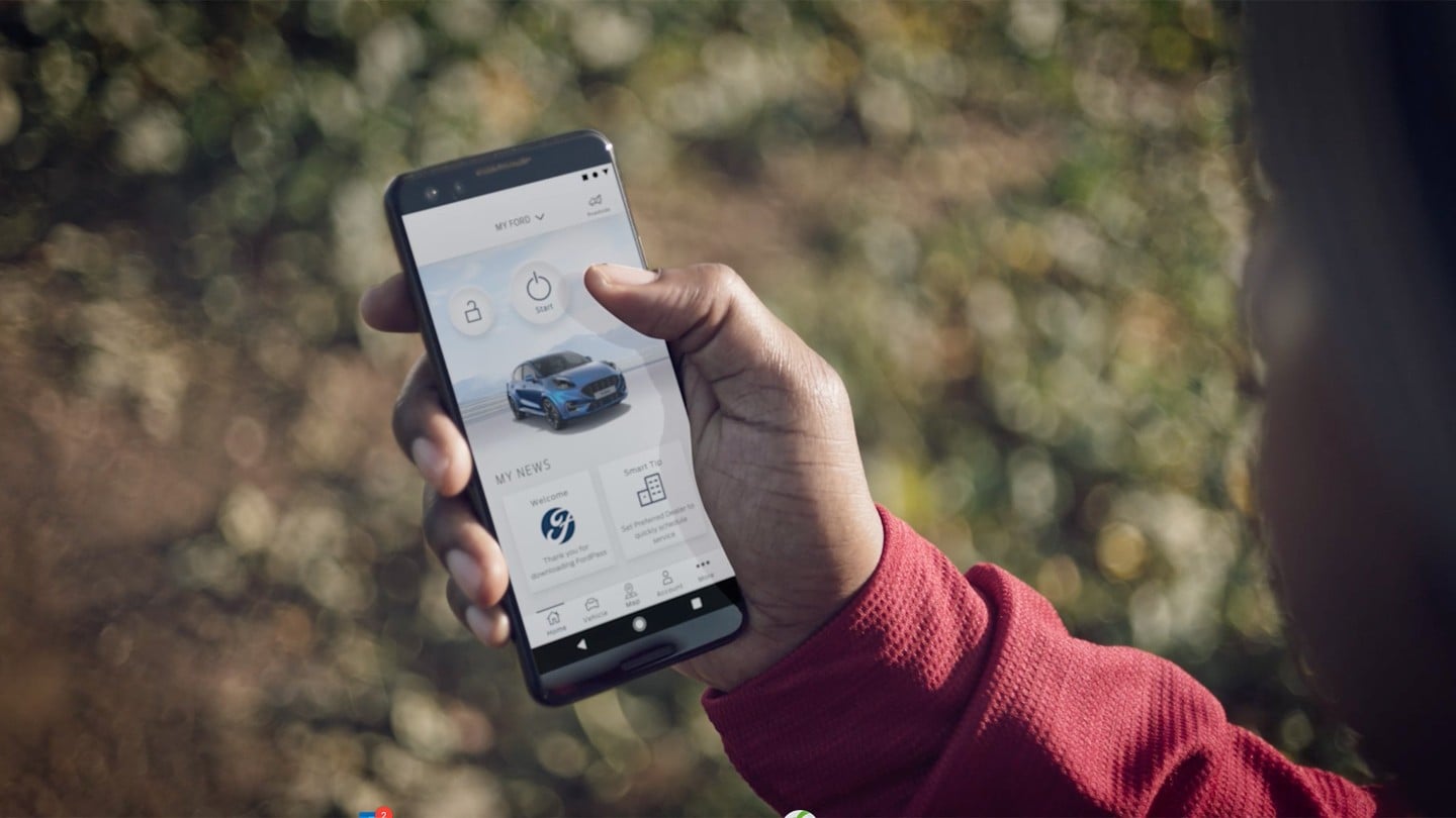 Application FordPass sur un smartphone, avec un Ford Puma ST de couleur bleue à l’écran