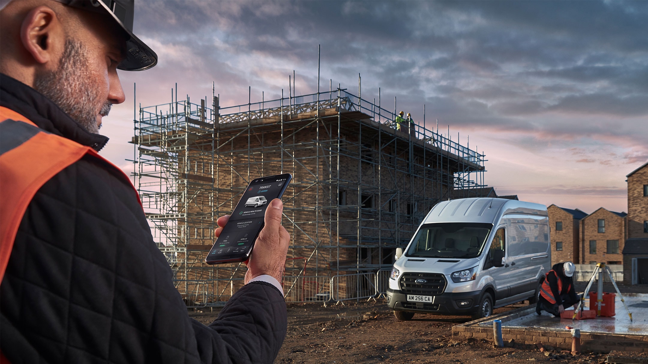 Ouvrier sur un chantier avec un téléphone portable à la main