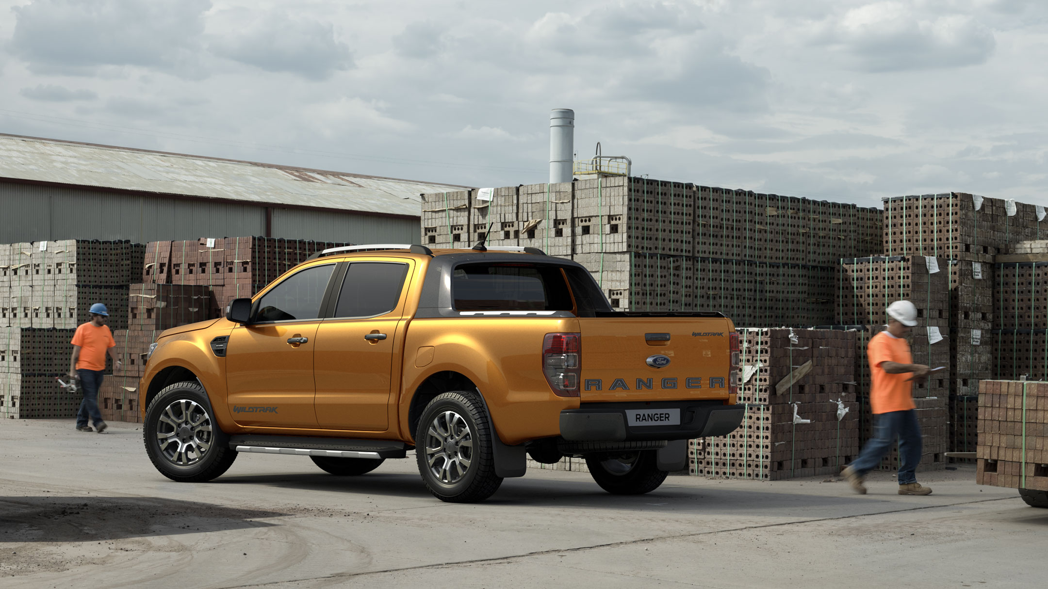 Ford Ranger couleur orange, vue arrière aux trois quarts, stationnant sur un chantier